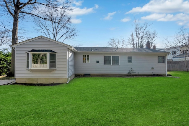 rear view of house featuring a lawn