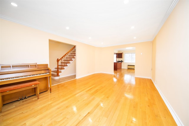 living room with ornamental molding, hardwood / wood-style floors, and radiator heating unit