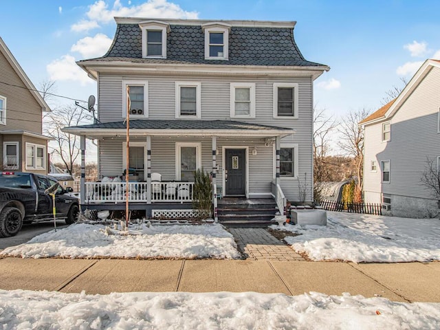 second empire-style home with a porch and mansard roof