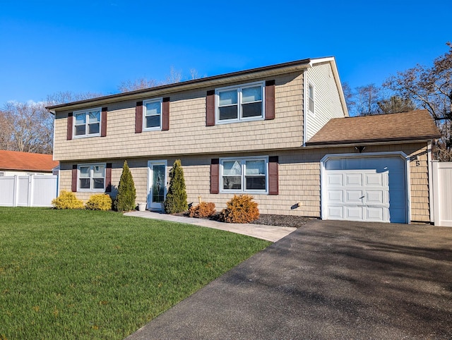 view of front of home with a front yard and a garage