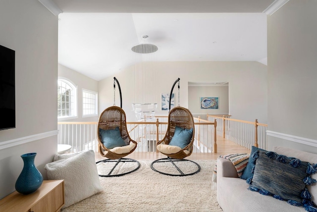 living area featuring vaulted ceiling, wood-type flooring, and crown molding