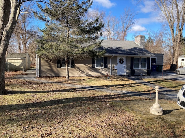 view of front of home featuring a front yard and a storage unit