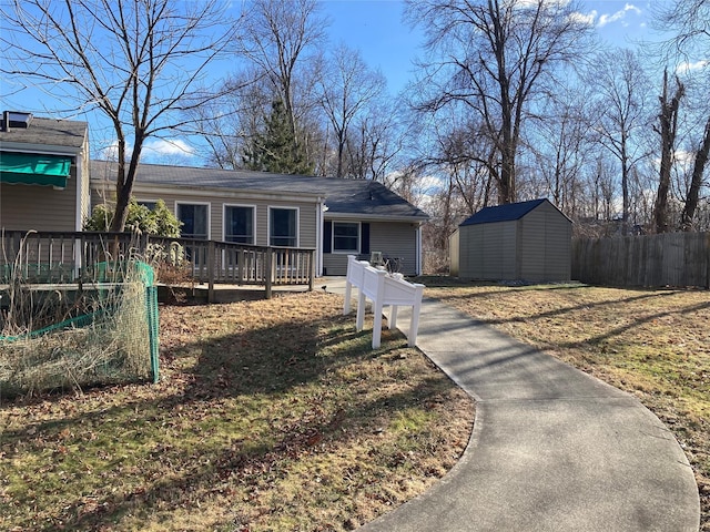 view of front of property featuring a deck, a front lawn, and a storage unit