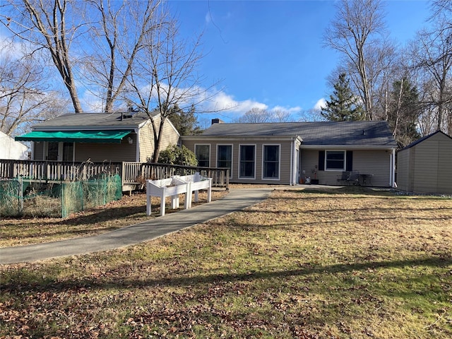 rear view of property with a yard and a wooden deck