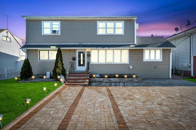 exterior space with fence, a shingled roof, a front yard, and entry steps