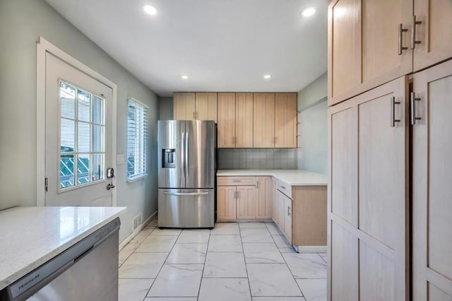 kitchen with light brown cabinetry, decorative backsplash, recessed lighting, marble finish floor, and stainless steel appliances