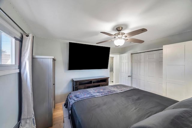 bedroom with a ceiling fan, wood finished floors, and a closet