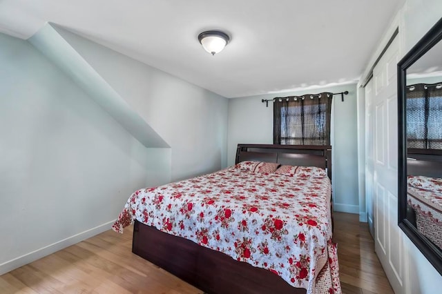 bedroom featuring a closet, baseboards, and wood finished floors