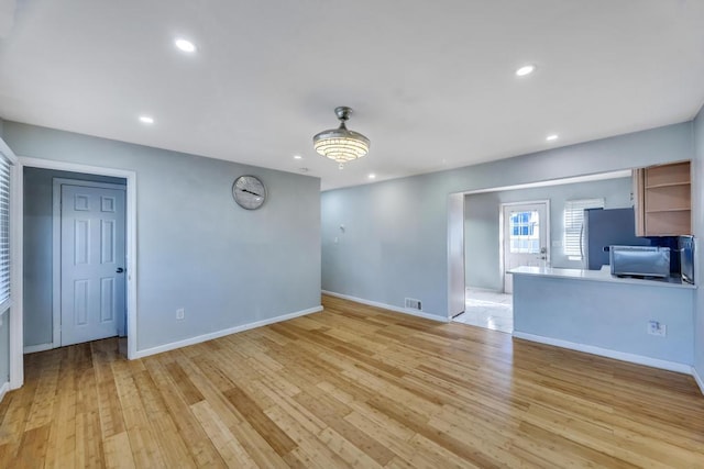 unfurnished living room featuring recessed lighting, visible vents, light wood-style flooring, and baseboards