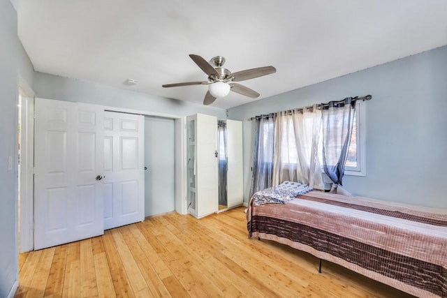 bedroom with a closet, light wood-type flooring, and ceiling fan