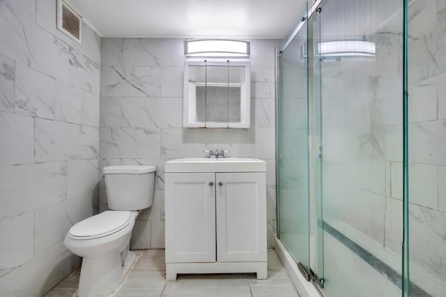 bathroom with vanity, visible vents, a shower stall, tile walls, and toilet