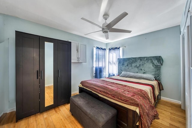 bedroom with a ceiling fan, baseboards, and light wood-type flooring