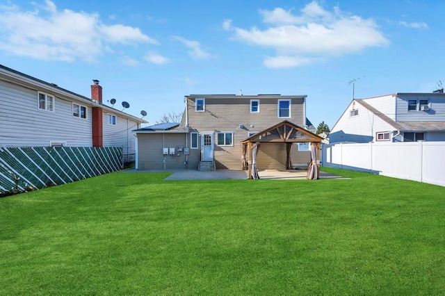 rear view of property featuring a gazebo, a patio area, a lawn, and fence private yard