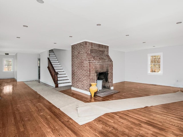 unfurnished living room with a brick fireplace and light hardwood / wood-style floors