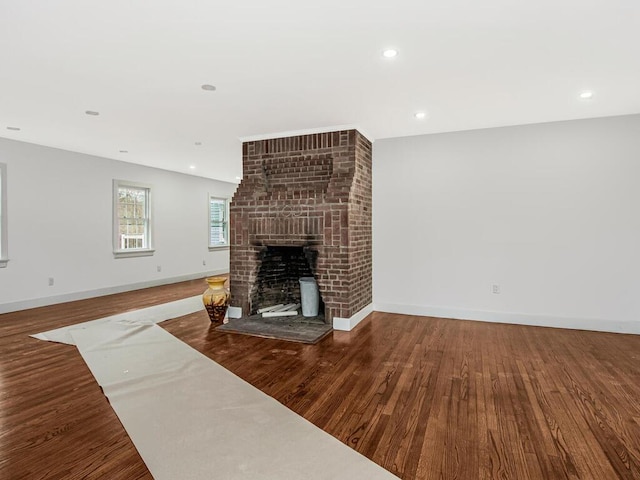 living room featuring a brick fireplace and hardwood / wood-style flooring