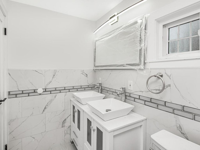 bathroom featuring tile walls, vanity, and toilet