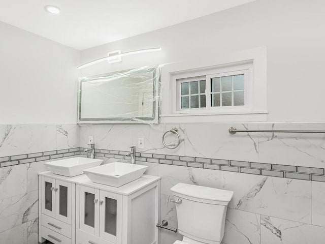 bathroom featuring tile walls, toilet, and vanity