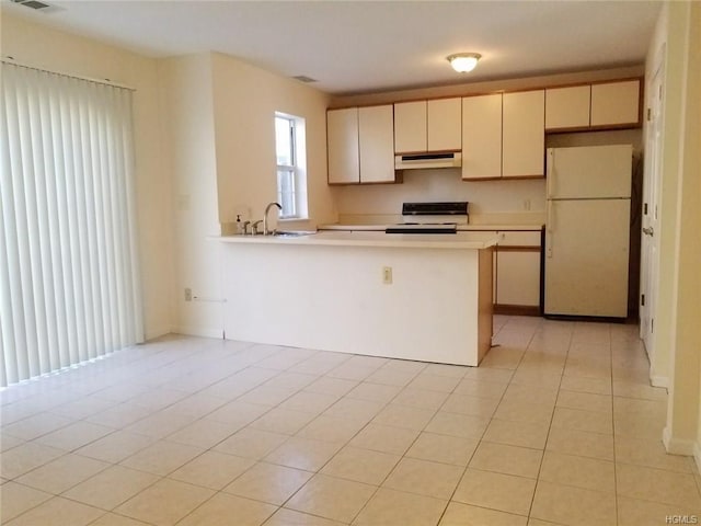 kitchen featuring electric range oven, light tile patterned flooring, white fridge, and kitchen peninsula