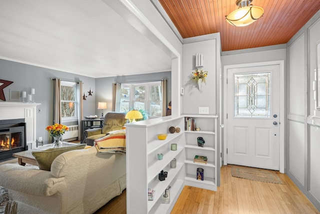 foyer with wooden ceiling, ornamental molding, and light hardwood / wood-style flooring