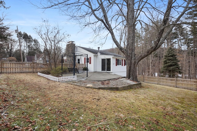 back of house with a lawn and a patio