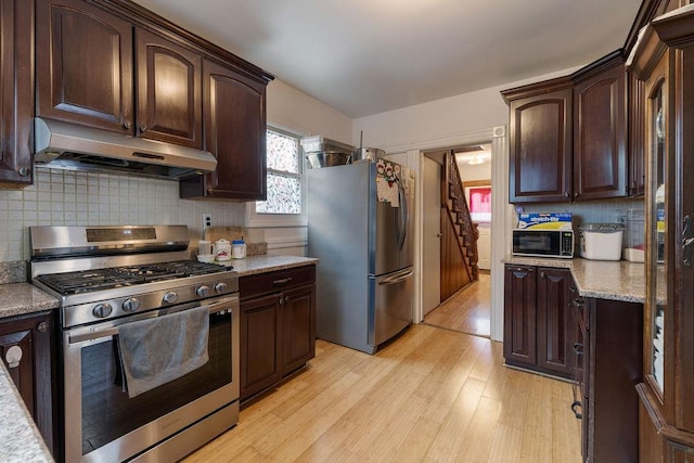 kitchen with stainless steel appliances, extractor fan, light wood-type flooring, and dark brown cabinets