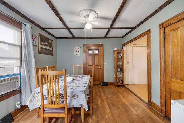 dining space featuring coffered ceiling, ceiling fan, light wood-type flooring, and a wealth of natural light