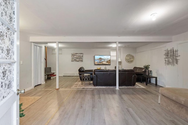 living room with light wood-type flooring and a baseboard heating unit