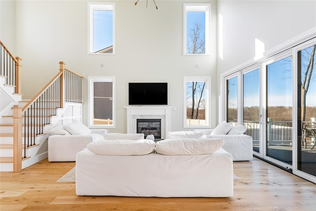 living room featuring a towering ceiling and light wood-type flooring