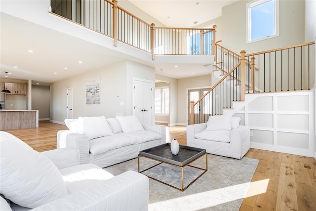 living room featuring light hardwood / wood-style floors and a towering ceiling