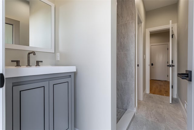 bathroom featuring a shower and vanity