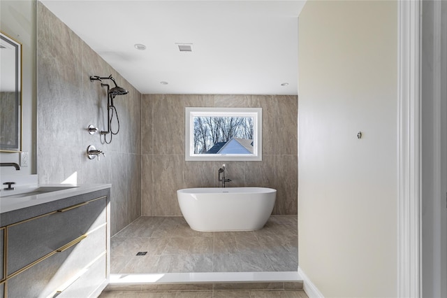 bathroom featuring independent shower and bath, tile walls, and vanity