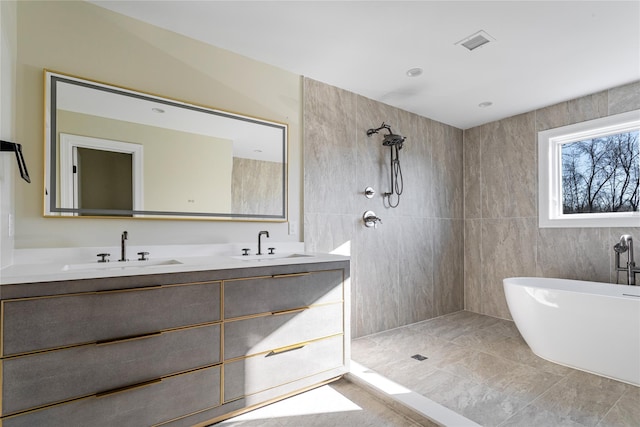 bathroom featuring tile patterned flooring, shower with separate bathtub, and vanity