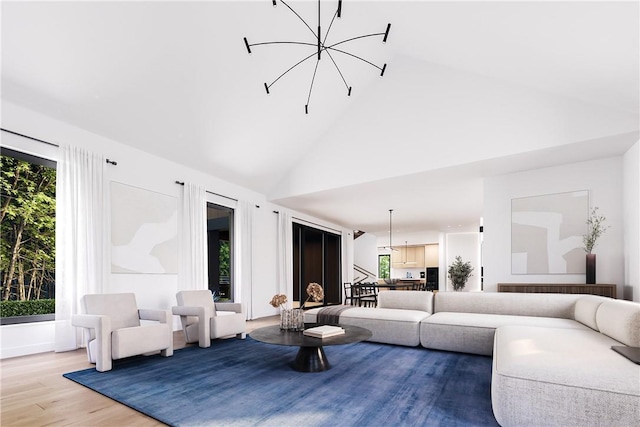 living room with high vaulted ceiling, a chandelier, and hardwood / wood-style floors