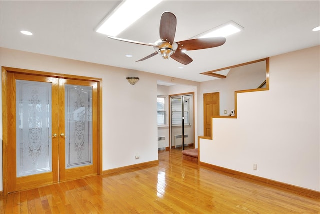 unfurnished room featuring radiator, wood-type flooring, and french doors