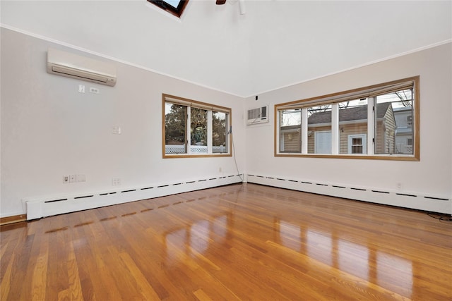 spare room featuring a baseboard heating unit, ornamental molding, hardwood / wood-style flooring, and a wall mounted air conditioner