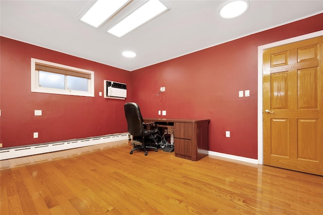 office space with a wall mounted AC, baseboard heating, and light hardwood / wood-style flooring