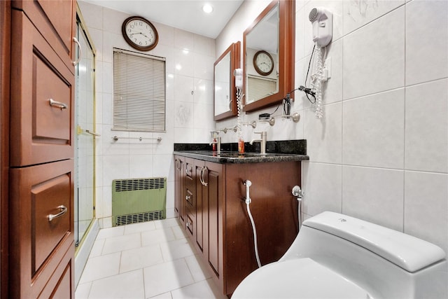 bathroom with a shower with door, tile walls, toilet, and radiator heating unit