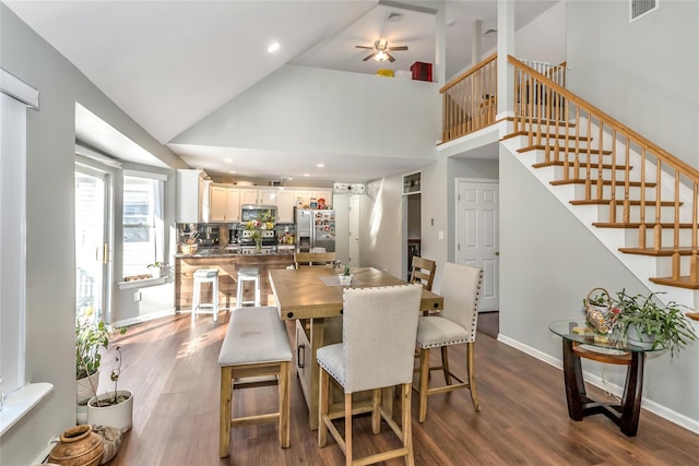 dining room featuring high vaulted ceiling, hardwood / wood-style floors, and ceiling fan