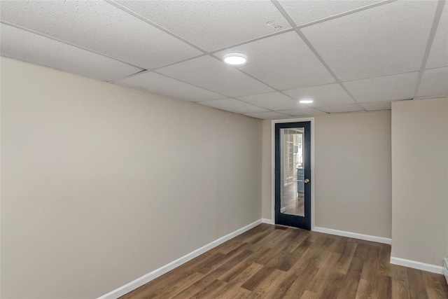 spare room with french doors, a drop ceiling, and dark hardwood / wood-style floors