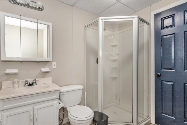 bathroom with toilet, an enclosed shower, vanity, and a drop ceiling