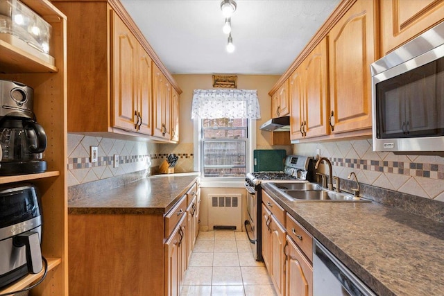 kitchen with appliances with stainless steel finishes, light tile patterned floors, decorative backsplash, and sink