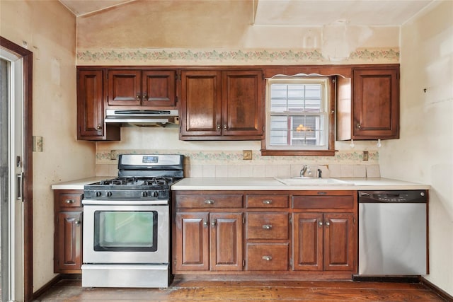 kitchen featuring lofted ceiling, stainless steel appliances, and sink