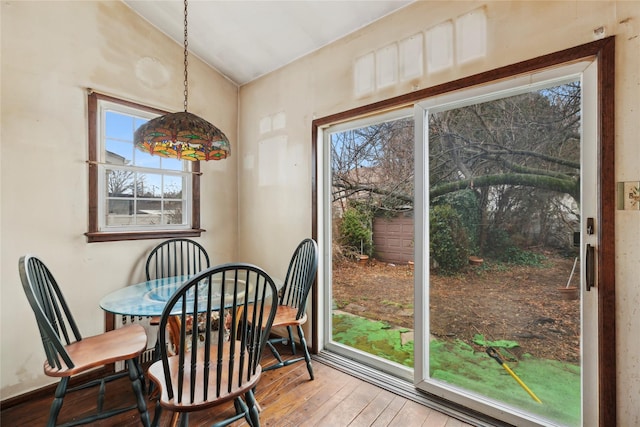 dining space featuring hardwood / wood-style flooring and vaulted ceiling