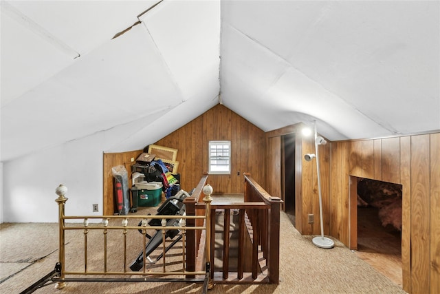 bonus room with vaulted ceiling, carpet, and wood walls