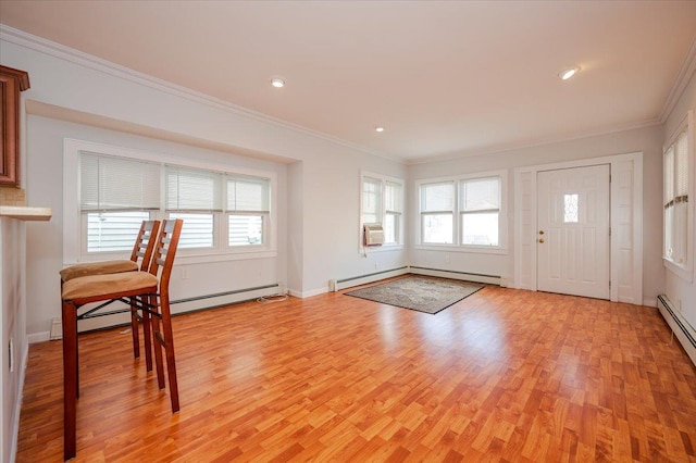 foyer featuring light wood-type flooring, a baseboard heating unit, crown molding, and a healthy amount of sunlight