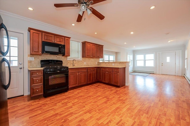 kitchen with baseboard heating, black appliances, light hardwood / wood-style floors, kitchen peninsula, and crown molding