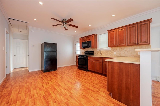 kitchen with light hardwood / wood-style floors, ceiling fan, backsplash, crown molding, and black appliances