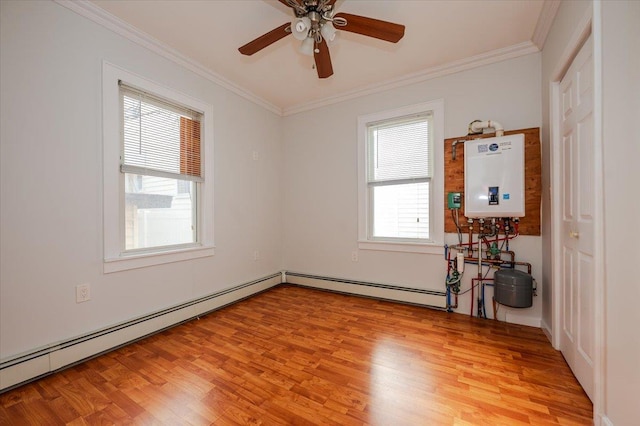 empty room featuring plenty of natural light, ornamental molding, water heater, and light wood-type flooring