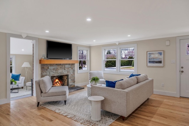 living room with a fireplace, light wood-type flooring, and ornamental molding