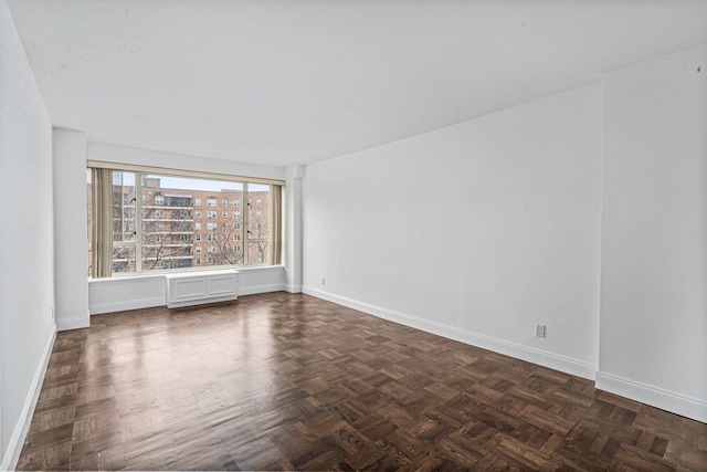 spare room with dark parquet flooring